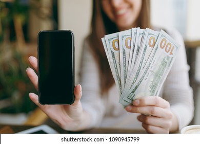 Close Up Photo Of Woman In Coffee Shop At Table With Bundle Of Dollars, Cash Money, Mobile Phone With Blank Empty Screen To Copy Space, Relaxing In Restaurant During Free Time. Female Rest In Cafe