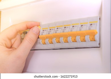 Close Up Photo Of Woman Hand Switching Off Automatic Fuse. Electric Circuit Breaker Fuse Box. Lighting Circuit. Overload Protection.