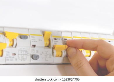 Close Up Photo Of Woman Hand Switching On Automatic Fuse. Electric Circuit Breaker Fuse Box. Lighting Circuit. Overload Protection.