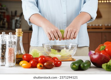 Close Up Photo of Woman Hands Making Fresh Salad on a Table Full with Organic Vegetables. - Powered by Shutterstock