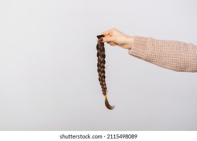 Close up photo of woman holding braided brown hair for donation