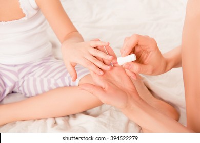 Close Up Photo Of Woman Painting Nails Of Her Child