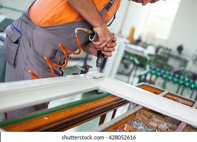 Close up photo of workers hands assembling PVC doors and windows. Selective focus. Factory for aluminum and PVC windows and doors production.