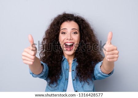 Close up photo yelling amazing beautiful her she lady arms fingers show thumbs up agreement cool wow omg great wearing casual jeans denim shirt clothes outfit isolated grey background