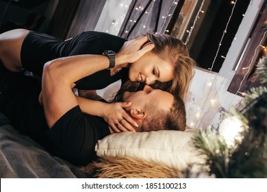 Close up photo of a young couple in an embrace on the bed during New Years. Emotions, passion, youth, hugs and kisses for Christmas. Young couple romantic new year time - Shutterstock ID 1851100213