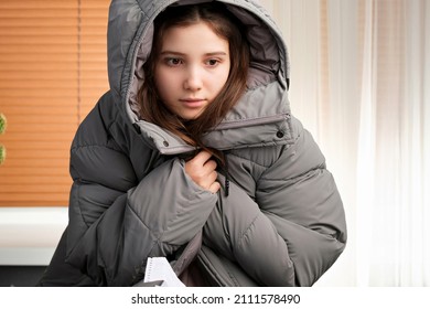 Close Up Photo Of A Young Girl Wearing Winter Coat Inside, Turning Off The Heating In The House Because Of Non-payment Of Bills.