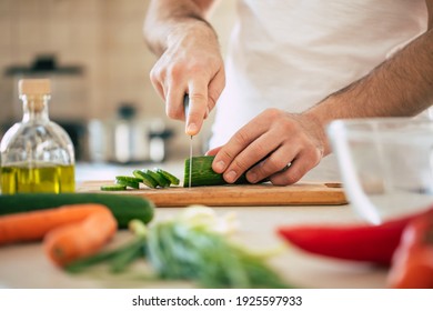 Close up photo of young male hands is preparing wonderful fresh vegan salad in the kitchen at home