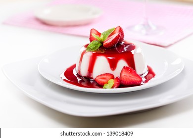 Close up photograph of a fancy panna cotta with strawberries