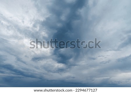 Close up photograph of turbulent looking storm clouds moving in the sky at sunset with dark blue shadows and texture isolated for sky replacement.