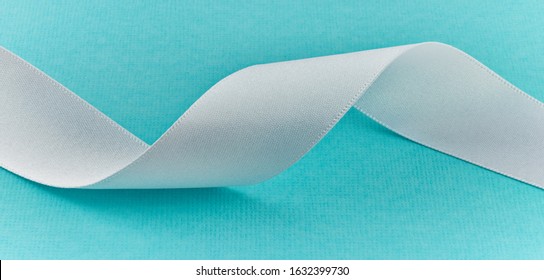 Close Up Photograph Of White Ribbon On Tiffany Blue Background