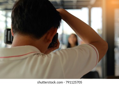 Close Up Of Photographer Checking Photograph Of Mountain Biker On Camera