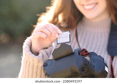 Close up of a photographer inserting card on dslr camera in winter