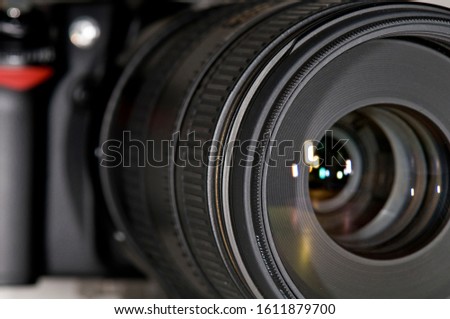 Close up of a photography camera lens as seen looking into the end of the lens with light reflection traveling down the lens and reflecting off the different pieces of glass