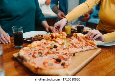 Close photography of pizza slices. People are eating pizza with olives. They are drinking juice.