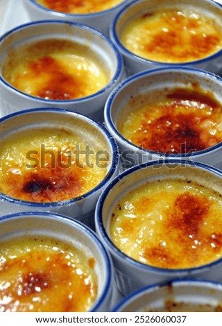 Close up photography of two vertical rows of small round dishes holding creme brulee