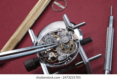 close up pic of watchmaker repairing vintage watch mechanism - Powered by Shutterstock
