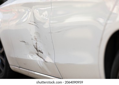 Close Up Picture Of Damage On White Car Door After Minor Accident