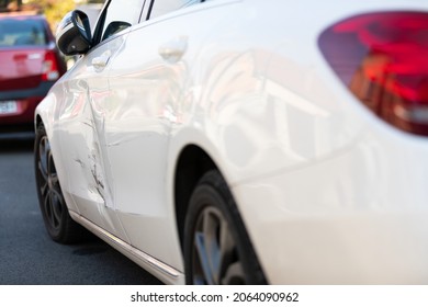 Close Up Picture Of Damage On White Car Door After Minor Accident