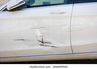 Close Up Picture Of Damage On White Car Door After Minor Accident