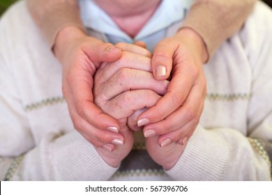 Close up picture of elderly hands with young caretaker's hands