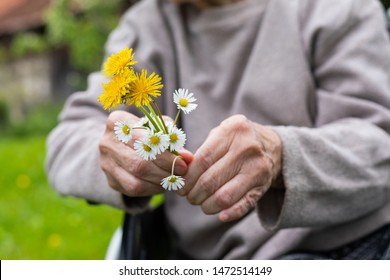 Close up picture of elderly shaking hands holding flower bouquet