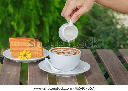 Close up picture of hand pour syrup in a cup of coffee.