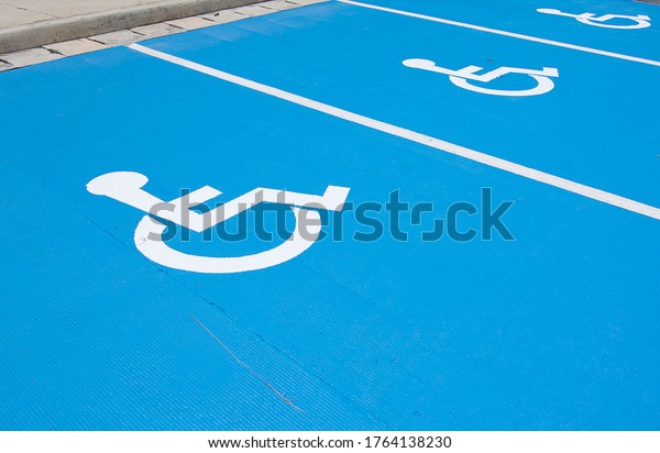 Close picture of Handicapped parking spot, white\
on blue asphalt