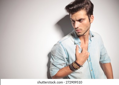 Close Up Picture Of A Handsome Man Pulling His Shirt While Looking Down.