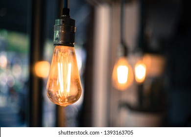 Close Up Picture Of A Hanging Orange Lightbulb In A Restaurant Or Café 