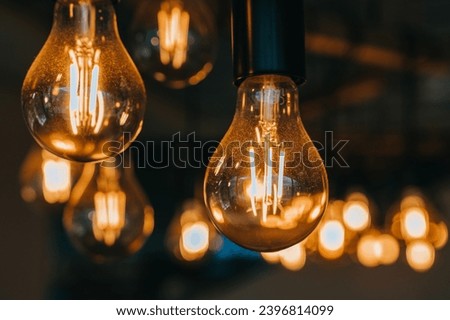 Close up picture of lit electric lamps against blurry lights of another lamps. Energy concept, electricity.