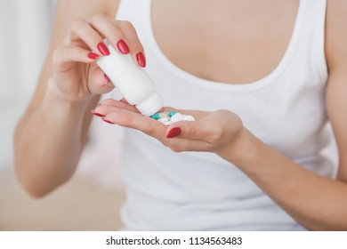 Close up picture of pills. Young woman taking pills
