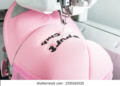 Close Up Picture Of Pink Embroidered Sport Cap On The Hoop Of Embroidery Machine