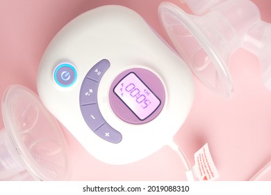 Close Up Picture Of Portable Electric Double Lactation Breast Pump On Pink Background. Battery And Direct Powersupply Can Be Used