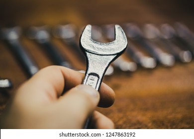 close up Picture of a spanner on a old vintage board in a black background - Shutterstock ID 1247863192