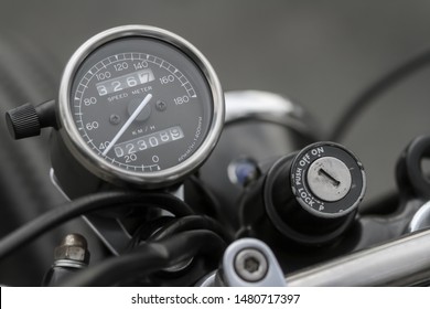 Close Up Picture Of The Vintage Style Of Dark Speedometer Gauge And Old On-off Ignition Switch From Retro Classic Motorcycle Background. 