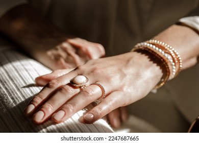Close up picture womans hand and gold jewelry 