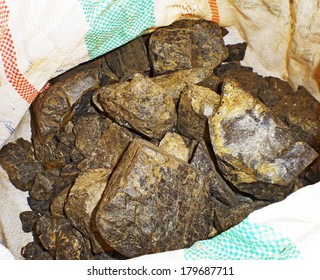Eine Nahaufnahme von Stücken Coltan Erz in der Tasche