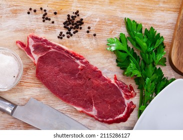close up of pieces of striploin served with parley on wooden table.. - Shutterstock ID 2115286127