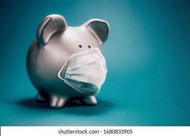 Close up of piggy bank, wearing protective face mask, isolated on blue background. Money saving concept in time of coronavirus pandemic. - Powered by Shutterstock