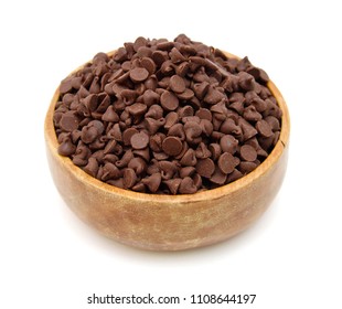 Close up pile of chocolate morsels in wooden bowl on white background - Shutterstock ID 1108644197