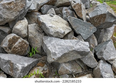 Close up of a pile of large crushed granite stones, to sell as building material. Selective focus. - Shutterstock ID 2282185233