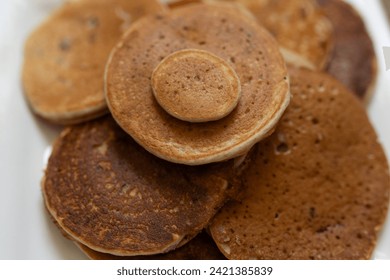 close up of a pile of pancakes with chocolate chips on a white plate  - Powered by Shutterstock