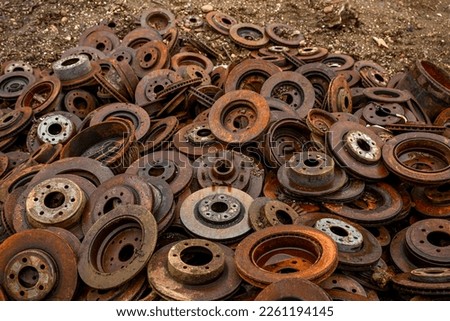 close up of pile of rusty car rotors at scrap yard 
