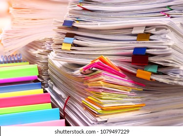 Close up pile of unfinished paperwork on office desk waiting to be managed. Stack of business paper. Report papers stacks. Business and finance concept.