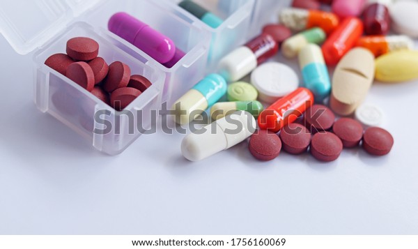 Close up Pill box daily take a medicine, with\
colorful of pills, tablets, and capsules. Drugs use for treatment\
the disease. Medication in medical clinic isolated in white\
background, has copy\
space.