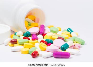 Close Up Pills And Capsules With White Plastic Drug Bottle.