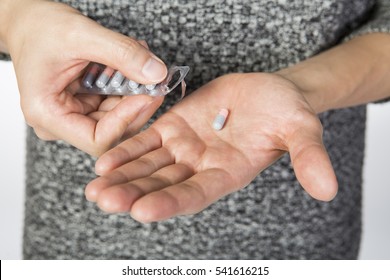 Close up of pills in hand, man in grey sweater with medicine - Shutterstock ID 541616215