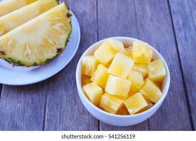 Close Up Of Pineapple Chunks In A Bowl On A Wooden Table.