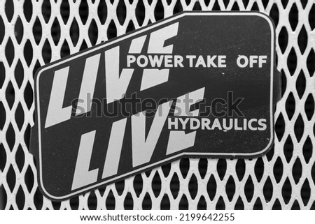 Close up of a plaque reading live power take off and live hydraulics on a vintage tractor 