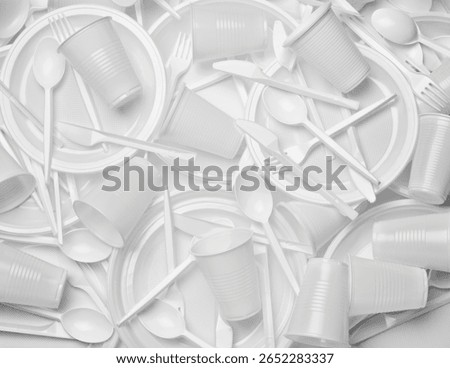 close up of plastic cutlery spoon, fork, knife, plate and cup on white background